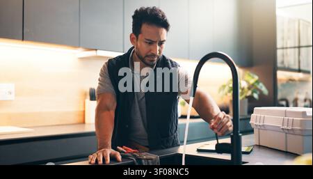 Faucet, sink and man in kitchen for plumbing service, maintenance and repair in home. Handyman, house and person with equipment, inspection and check Stock Photo