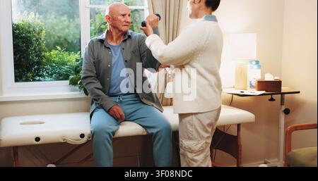 Old man, dumbbells and physiotherapist in office for fitness, guidance and physio for recovery. Therapist, helping and senior person in workplace with Stock Photo