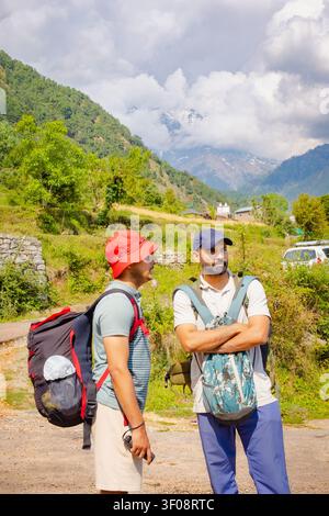 Two men with backpacks standing on a mountain trail near Kareri Lake in the scenic Dharamshala region of India. Stock Photo