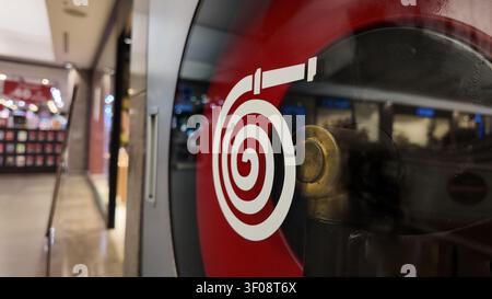 Closeup Fire Hose Reel Safety Sign On Glass In Shopping Mall Corridor With Reflections Stock Photo