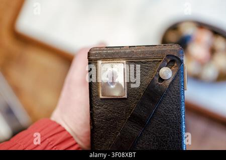 Hand holding an old camera, viewing an image of a senior man in its viewfinder Stock Photo