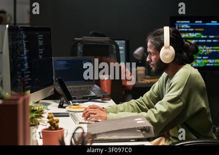 Man Coding at Desk in Software Development Office Stock Photo