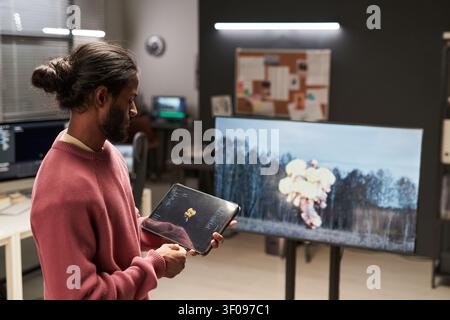 Man Reviewing Visual Effects Content on Tablet in Studio Stock Photo
