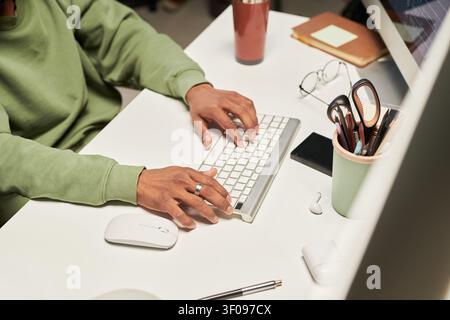Unknown Man Typing on Keyboard in Home Office Workspace Stock Photo