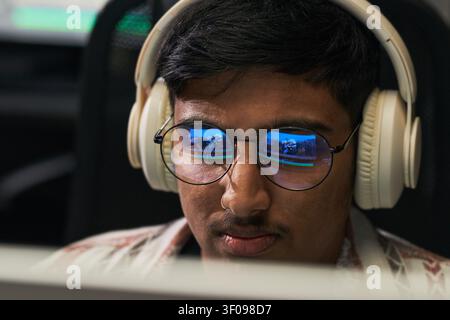 Asian Man Wearing Headphones While Gaming on Computer Stock Photo
