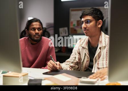 Male Coworkers Collaborating on Digital Design Project in Office Stock Photo