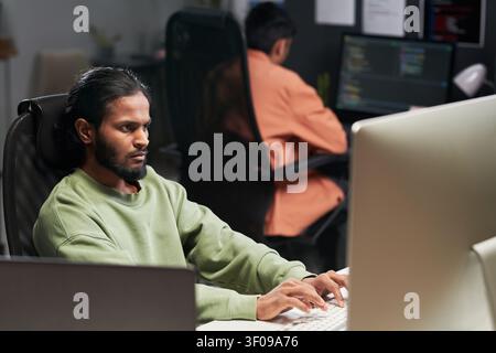 Man Coding at Desktop in Software Development Office Stock Photo