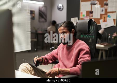 Indian Man Using Graphics Tablet in Creative Office Stock Photo