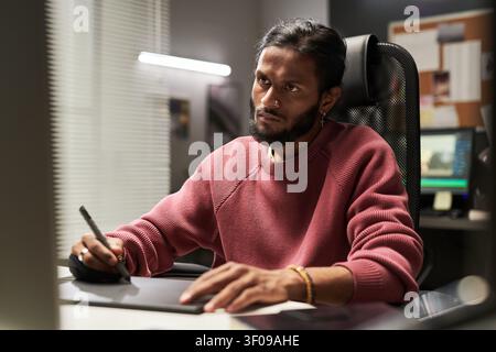 Man Using Graphic Tablet in Creative Office Workspace Stock Photo
