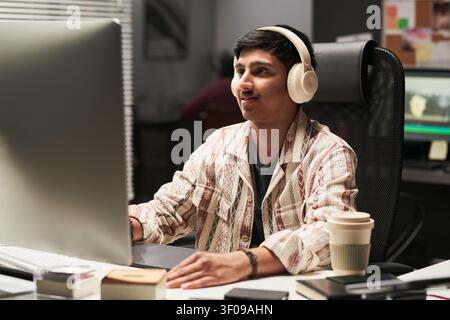 Asian Man Editing Video at Computer in Creative Workplace Stock Photo