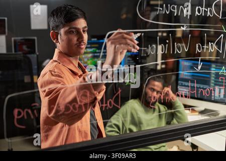 Asian Man Writing Data Flow Diagram for Software Development Stock Photo