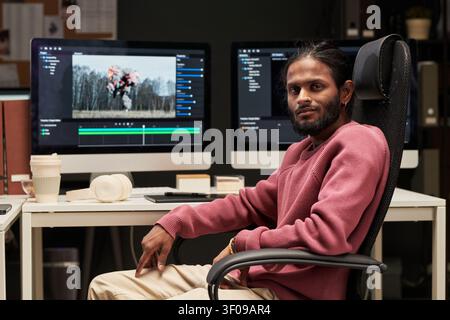 Portrait of Indian Man Editing Video in Creative Office Stock Photo