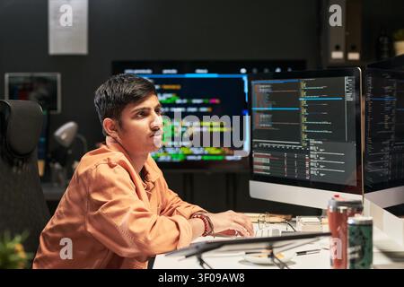 Young Developer Coding Software at Desk for Technology Startup Stock Photo