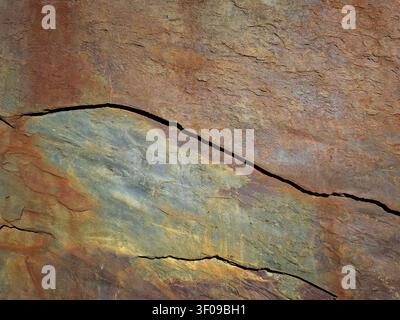Textured surface features layers of brown stone, displaying rich colors and visible cracks. The natural patterns create an organic look, highlighting Stock Photo