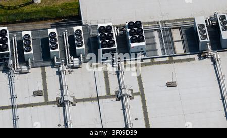 Aerial view of industrial rooftop featuring multiple HVAC cooling units, ventilation pipes, and metal walkways in Nieuwegein, Utrecht, Netherlands. Stock Photo