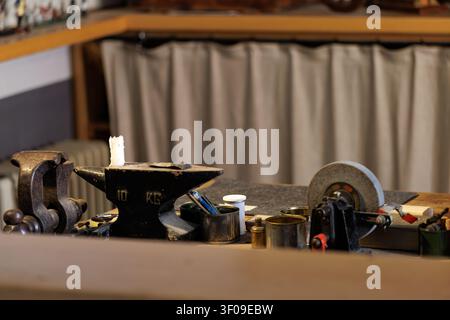 Vintage workshop tools with anvil and grinding wheel on traditional workbench Stock Photo