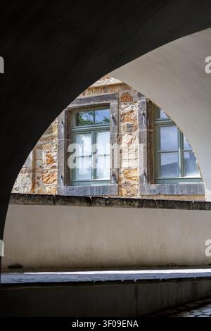 Stone fortress windows framed by arched passage in historic masonry architecture Stock Photo