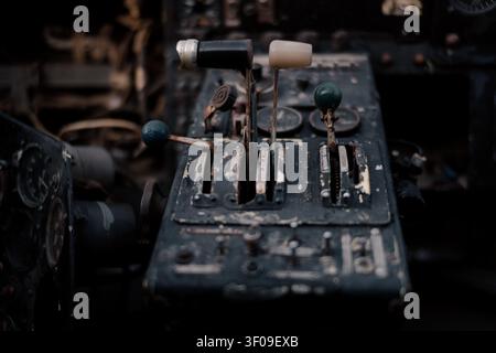 Interior of an abandoned vintage biplane cockpit showing a worn control lever and old aircraft instrument panel in close-up. Stock Photo