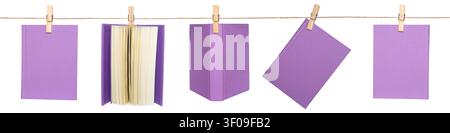 Five purple books are hanging on a string with clothespins. The books are set against a plain background. Stock Photo
