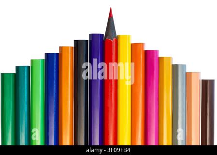 Different colored pencils are lined up in a row with one red pencil placed in the center at the top. The setting is simple and focused on the pencils. Stock Photo