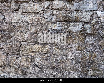 This wall features many stones of different shapes and sizes stacked together. The surface shows some wear and natural patterns. Stock Photo