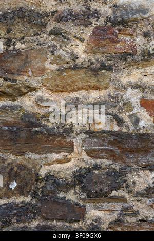 Weathered natural stone wall texture with rustic masonry pattern background Stock Photo