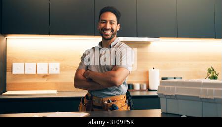 Plumber, tools and portrait of man in kitchen for plumbing service, maintenance and repair. Handyman, home and person with utility belt, pride and Stock Photo