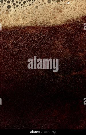 Dark beer foam texture with dense bubbles and rich stout layer. Stock Photo