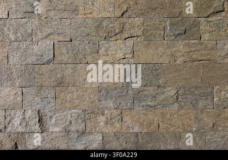 Brown and gray exterior tiles wall made of limestone. Background and texture. Stock Photo
