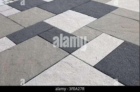 Black, gray and white concrete tiles for outdoor flooring with natural stone effect. Close up. Background and texture. Stock Photo