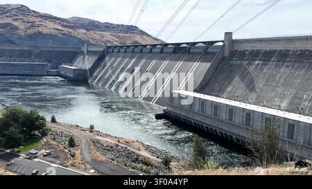 A close up view of the massive concrete spillway and face of a hydroelectric dam with the river below. Stock Photo