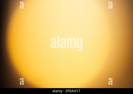 Circular source of soft golden light creates a warm glow, with a blurred background featuring smooth gradients and soft textures Stock Photo