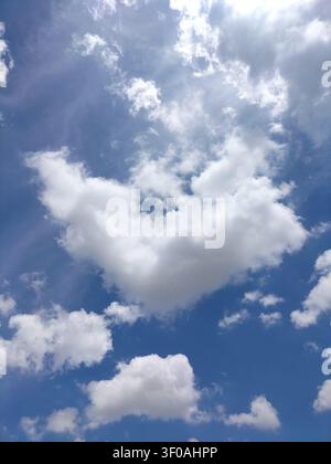 Beautiful vibrant blue sky with fluffy white clouds on a bright sunny day in Thailand. Stock Photo