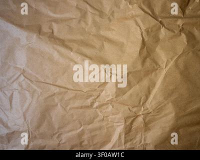 High-resolution background featuring the textured surface of rumpled brown craft paper. The organic folds and creases create a natural, rustic aesthet Stock Photo