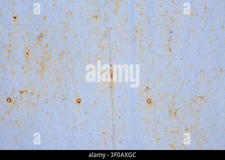 Texture of gray steel sheet metal with rust stains and old rivets. Industrial background and metal texture with traces of corrosion. Vintage architect Stock Photo