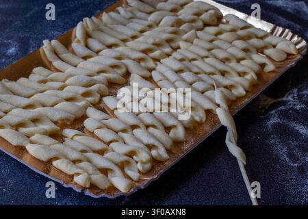 Close up of uncooked dry busiate spiral pasta pieces showcasing the unique hand-rolled texture. Stock Photo