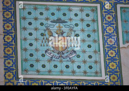 A flat lay macro shot of a traditional ceramic tile mosaic mural decoration on a building wall. The artwork displays complex geometric star patterns a Stock Photo