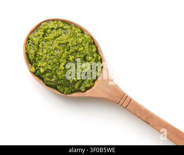 Top view of green pesto sauce in wooden spoon isolated on white Stock Photo