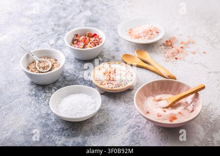 Assortment of gourmet salts in small bowls, including Himalayan and rose petal infused Stock Photo