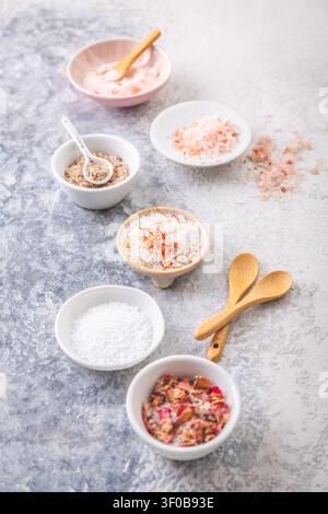 Assortment of gourmet salts in small bowls, including Himalayan and rose petal infused Stock Photo