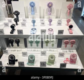 Personal hand-held cooling fans for sale in a railway station shop on Zaragoza-Delicias station concourse in Spain. Stock Photo