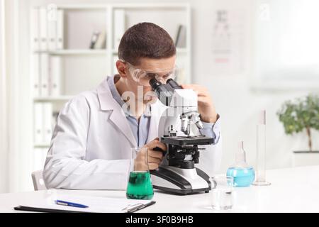 Laboratory scientist looking through microscope in an office Stock Photo