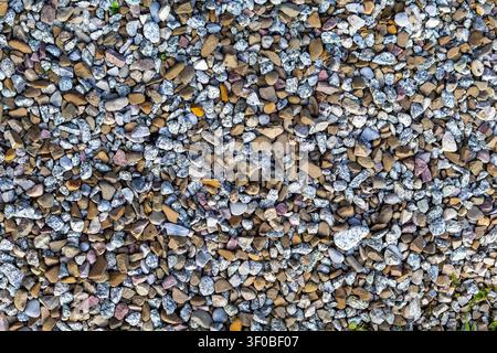 Mixed Gravel Stones Texture Background. Mixed gravel stones fill the frame with varied shapes, rough textures, and natural gray, brown, white, and tan Stock Photo