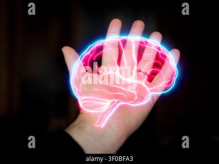 Human hand displays a glowing digital brain illustration with neon outlines, set against a dark background, representing technology and neuroscience t Stock Photo