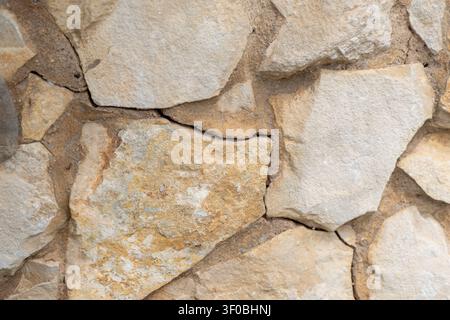 Detailed view of a rustic stone wall construction showcasing the rough surfaces and varied colors of the natural rock elements Stock Photo