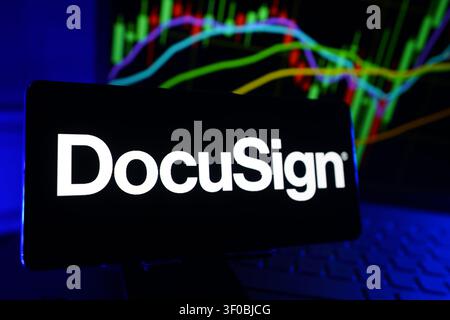 Docusign Inc Logo Displayed On A Smartphone Screen In Front Of A Computer Showing Stock Market Financial Performance Charts Stock Photo