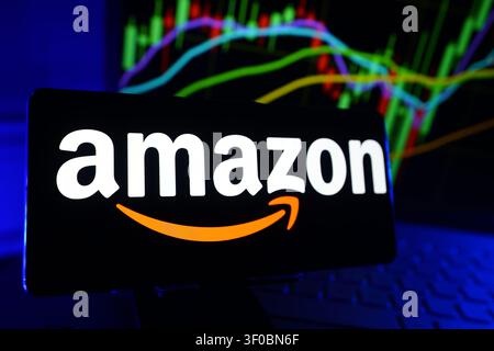 Amazon.Com Inc Logo Displayed On A Smartphone Screen In Front Of A Computer Showing Stock Market Financial Performance Charts Stock Photo