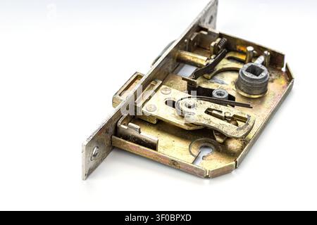 Detailed macro photograph of an opened brass mortise door lock mechanism displaying complex internal workings including metal springs latches tumblers Stock Photo