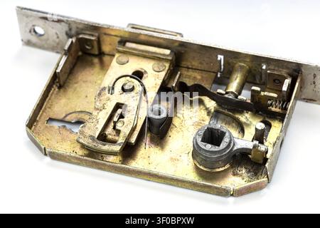 Macro photograph showing the intricate internal mechanism of a vintage brass door mortise lock with visible springs, latch bolt, deadbolt, square spin Stock Photo