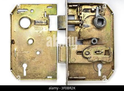 Detailed close up of a vintage brass mortise door lock fully disassembled, exposing complex internal components including springs, levers, latch bolt, Stock Photo